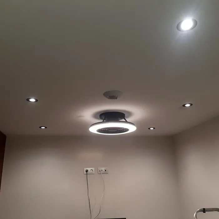 Techo de una habitación con ojos de buey led y un ventilador de palas retráctiles instalados por Electricidad Lansa